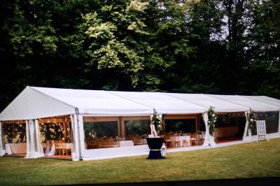 Carte de visite orange avec coordonnées et services d'une entreprise de location de barnums, incluant chauffage et options.