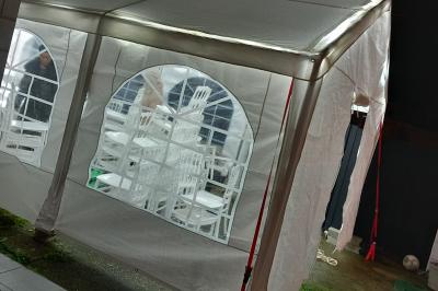 Carte de visite orange avec coordonnées et services d'une entreprise de location de barnums, incluant chauffage et options.