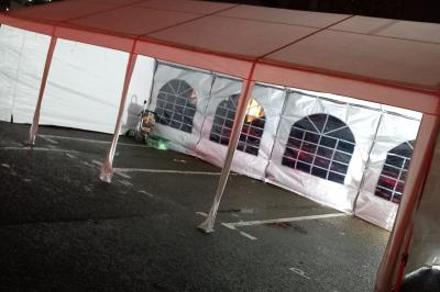 Carte de visite orange avec coordonnées et services d'une entreprise de location de barnums, incluant chauffage et options.