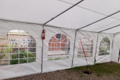 Carte de visite orange avec coordonnées et services d'une entreprise de location de barnums, incluant chauffage et options.