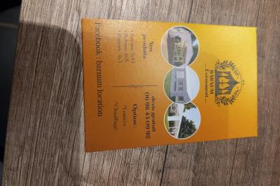 Carte de visite orange avec coordonnées et services d'une entreprise de location de barnums, incluant chauffage et options.