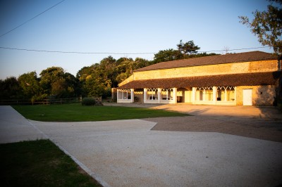 Étang entouré de végétation dense au coucher du soleil, avec une lumière dorée illuminant les arbres et l'eau.
