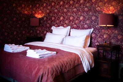 Salle de réception lumineuse avec des tables rondes dressées, des chaises blanches et des chandeliers élégants.