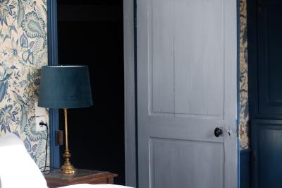 Salle de réception lumineuse avec des tables rondes dressées, des chaises blanches et des chandeliers élégants.