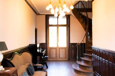 Salle de réception lumineuse avec des tables rondes dressées, des chaises blanches et des chandeliers élégants.