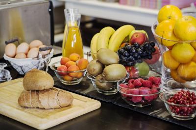Salle de réception lumineuse avec des tables rondes dressées, des chaises blanches et des chandeliers élégants.