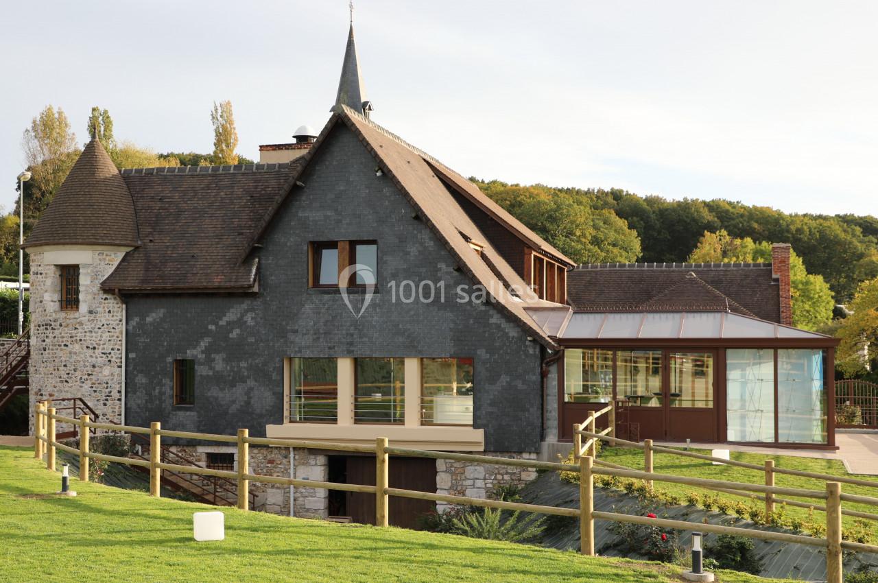 Location salle Saint-Samson-de-la-Roque (Eure) - Manoir Néo Normand #29 Bâtiment en pierre et ardoise avec une extension moderne en verre, entouré de verdure et d'une clôture en bois.