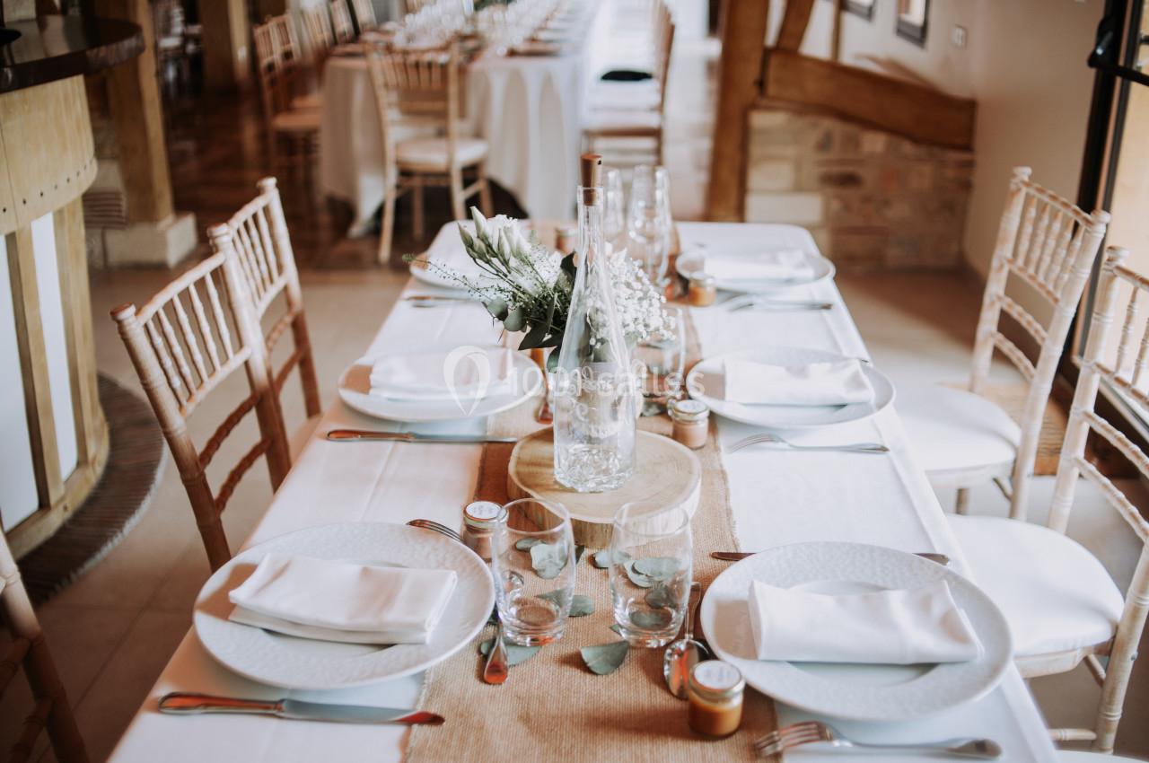 Location salle Saint-Samson-de-la-Roque (Eure) - Manoir Néo Normand #5 Table dressée avec nappes blanches, assiettes, verres, couverts et décoration florale dans une salle lumineuse.