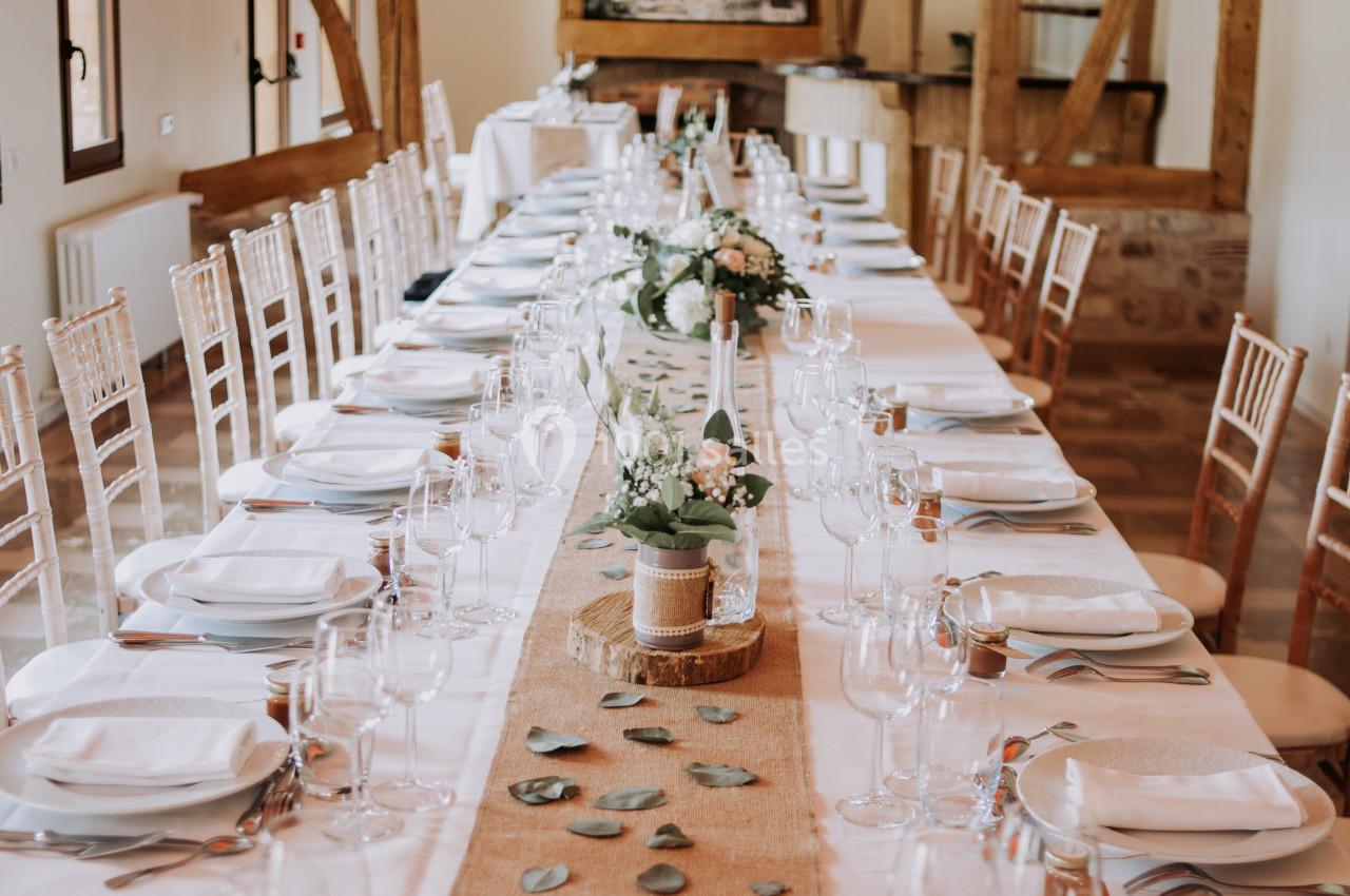 Location salle Saint-Samson-de-la-Roque (Eure) - Manoir Néo Normand #4 Grande table de réception décorée avec nappes blanches, chemins de table en toile de jute, fleurs et vaisselle élégante.
