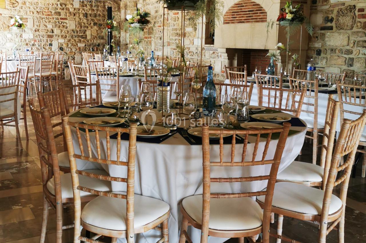 Location salle Saint-Samson-de-la-Roque (Eure) - Manoir Néo Normand #20 Salle de réception avec tables rondes dressées, chaises en bois clair et décorations florales élégantes.