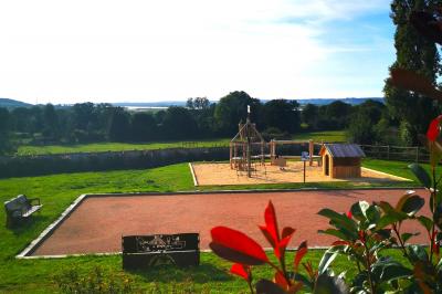Miniature Location salle Saint-Samson-de-la-Roque (Eure) - Manoir Néo Normand #35 Passerelle en bois surplombant un jardin fleuri avec des arbres et un ciel dégagé en arrière-plan.