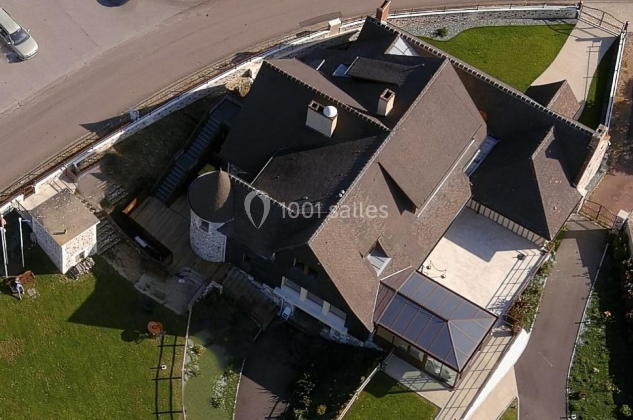 Location salle Saint-Samson-de-la-Roque (Eure) - Manoir Néo Normand #28 Vue aérienne d'un bâtiment avec toit en pente, terrasse, véranda et espaces verts environnants.