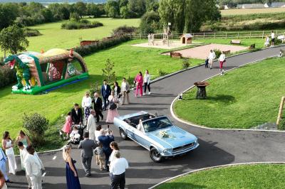 Miniature Location salle Saint-Samson-de-la-Roque (Eure) - Manoir Néo Normand #19 Passerelle en bois surplombant un jardin fleuri avec des arbres et un ciel dégagé en arrière-plan.