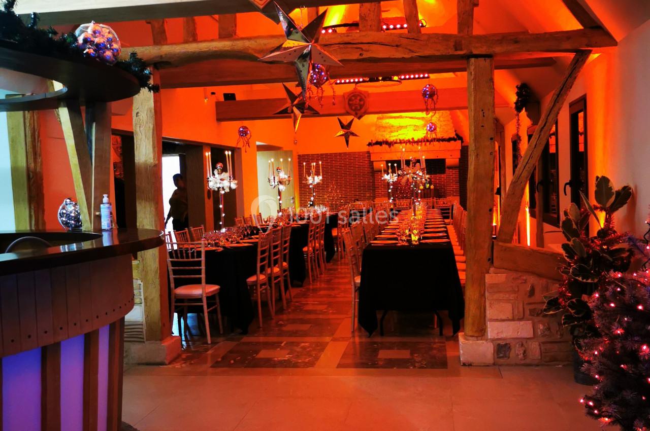 Location salle Saint-Samson-de-la-Roque (Eure) - Manoir Néo Normand #60 Salle décorée avec des tables dressées, éclairage chaleureux et poutres apparentes en bois.