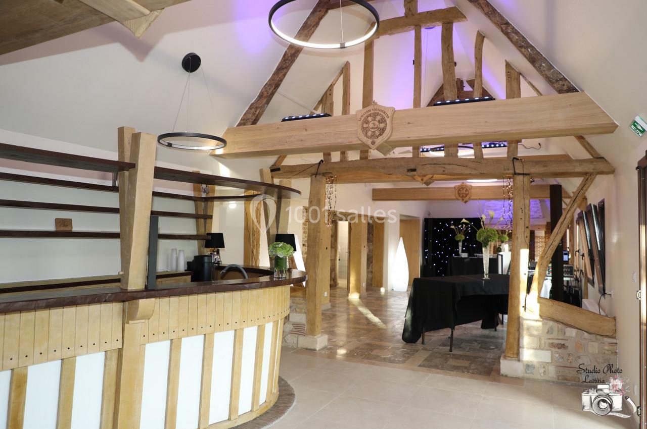 Location salle Saint-Samson-de-la-Roque (Eure) - Manoir Néo Normand #52 Intérieur d'une salle avec charpente en bois apparente, comptoir en bois et tables décorées pour un événement.