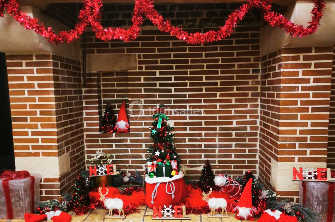 Location salle Saint-Samson-de-la-Roque (Eure) - Manoir Néo Normand #59 Décoration de Noël avec cheminée en briques, guirlandes rouges, sapin miniature, figurines et lettres formant ’Noël’.