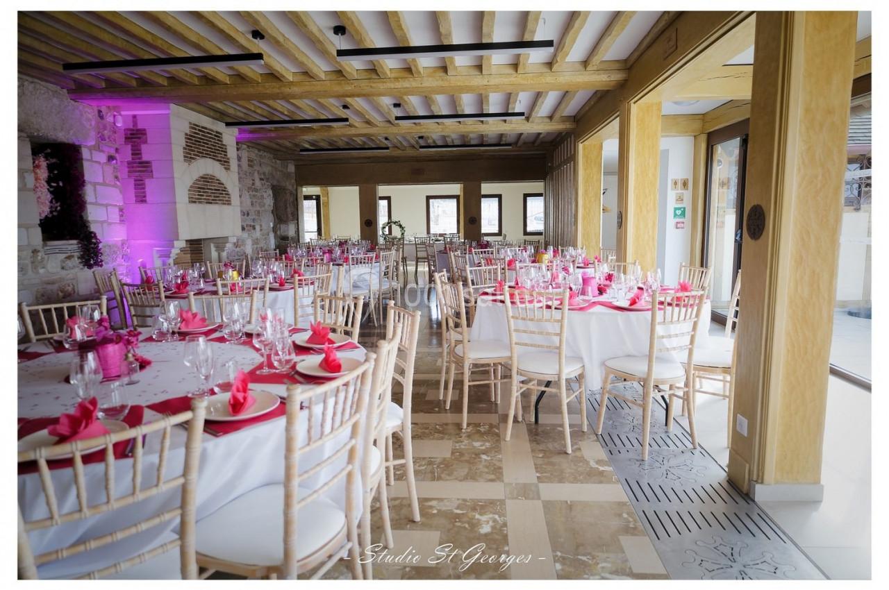 Location salle Saint-Samson-de-la-Roque (Eure) - Manoir Néo Normand #17 Salle de réception lumineuse avec tables rondes décorées de nappes blanches et serviettes roses, chaises en bois clair.