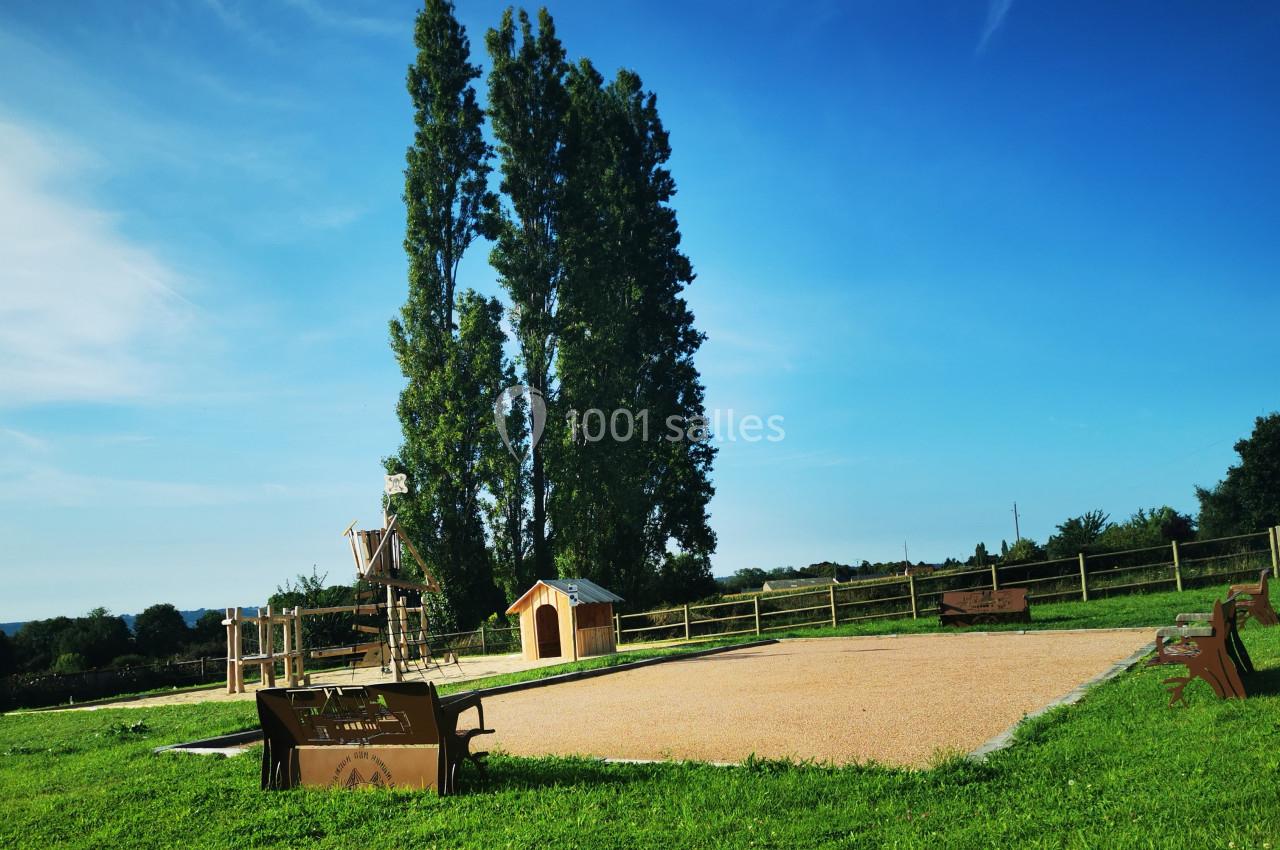 Location salle Saint-Samson-de-la-Roque (Eure) - Manoir Néo Normand #82 Aire de jeux en plein air avec toboggan, cabane en bois, bancs et pelouse, entourée d'arbres et de clôtures.