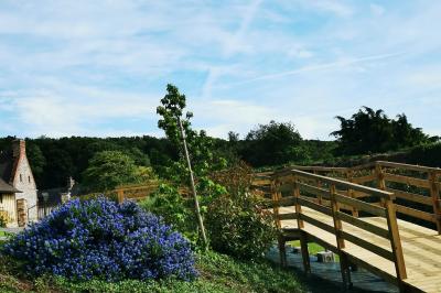 Miniature Location salle Saint-Samson-de-la-Roque (Eure) - Manoir Néo Normand #103 Passerelle en bois surplombant un jardin fleuri avec des arbres et un ciel dégagé en arrière-plan.