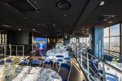 Vue aérienne de Paris au crépuscule, avec la tour Eiffel illuminée et les Invalides visibles au premier plan.