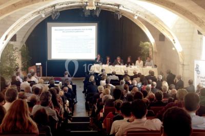 Salle voûtée avec murs en pierre, tables et chaises modernes, buffet en arrière-plan et éclairage chaleureux.