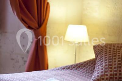 Salle voûtée avec murs en pierre, tables et chaises modernes, buffet en arrière-plan et éclairage chaleureux.