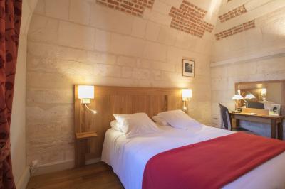 Salle voûtée avec murs en pierre, tables et chaises modernes, buffet en arrière-plan et éclairage chaleureux.