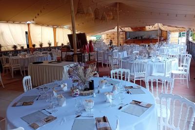 Statue en pierre représentant une femme dans un jardin avec des pots en terre cuite et une allée pavée en arrière-plan.