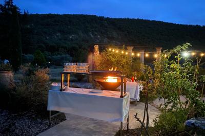 Statue en pierre représentant une femme dans un jardin avec des pots en terre cuite et une allée pavée en arrière-plan.