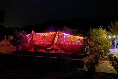 Statue en pierre représentant une femme dans un jardin avec des pots en terre cuite et une allée pavée en arrière-plan.