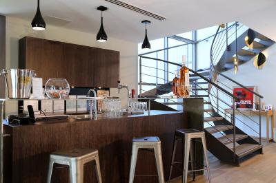 Table dressée pour un dîner en extérieur sous une structure lumineuse avec guirlandes, près d'un bâtiment moderne.
