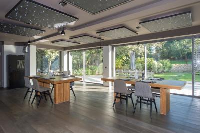 Table dressée pour un dîner en extérieur sous une structure lumineuse avec guirlandes, près d'un bâtiment moderne.