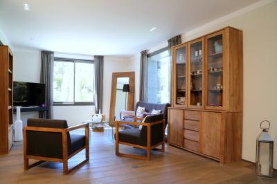 Table dressée pour un dîner en extérieur sous une structure lumineuse avec guirlandes, près d'un bâtiment moderne.