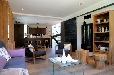 Table dressée pour un dîner en extérieur sous une structure lumineuse avec guirlandes, près d'un bâtiment moderne.