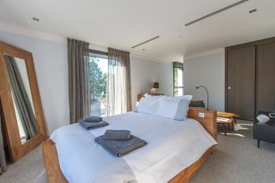 Table dressée pour un dîner en extérieur sous une structure lumineuse avec guirlandes, près d'un bâtiment moderne.