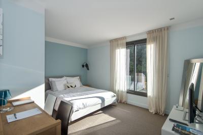 Table dressée pour un dîner en extérieur sous une structure lumineuse avec guirlandes, près d'un bâtiment moderne.