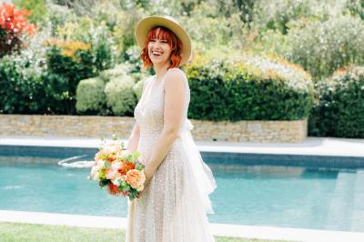 Table dressée pour un dîner en extérieur sous une structure lumineuse avec guirlandes, près d'un bâtiment moderne.