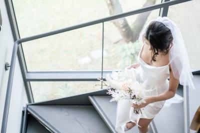 Table dressée pour un dîner en extérieur sous une structure lumineuse avec guirlandes, près d'un bâtiment moderne.