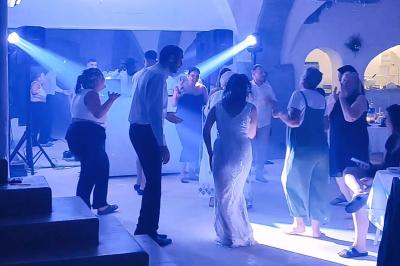 Personnes dansant dans une salle éclairée par des projecteurs bleus, ambiance festive et décontractée.