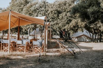 Sanitaires modernes en bois avec cabines, lavabos et vue sur un espace extérieur arboré.