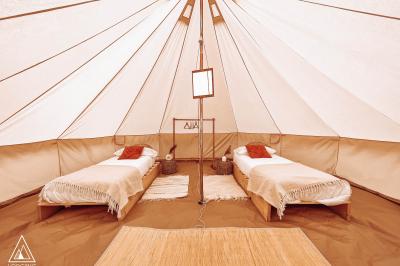 Sanitaires modernes en bois avec cabines, lavabos et vue sur un espace extérieur arboré.