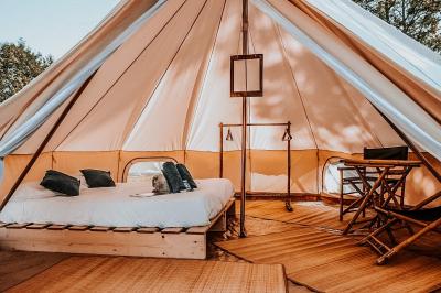 Sanitaires modernes en bois avec cabines, lavabos et vue sur un espace extérieur arboré.