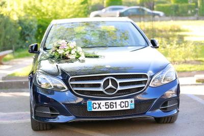 Table ronde avec verres vides, assiettes empilées, couverts, serviettes et desserts en arrière-plan.