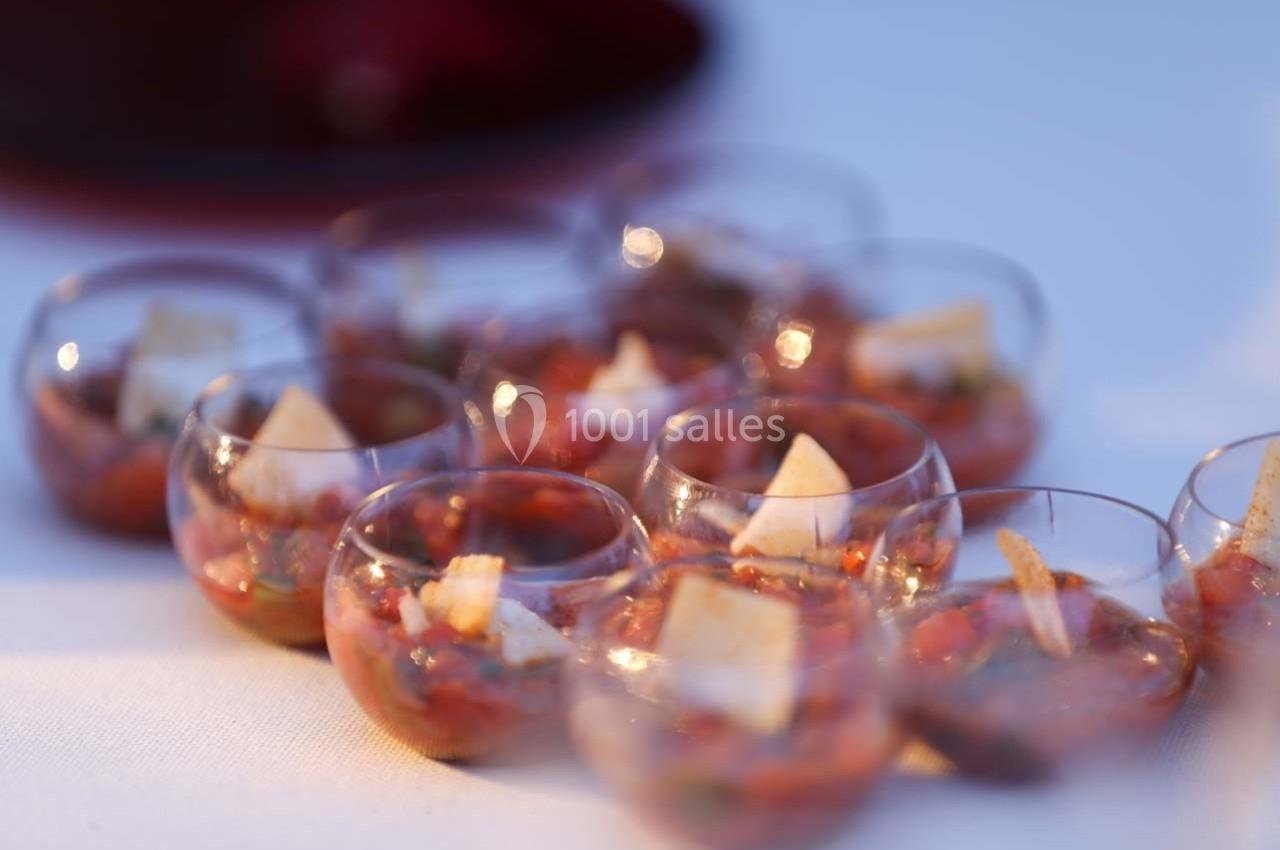 Verrines de tartare de légumes garnies de morceaux de pain, disposées sur une table blanche.