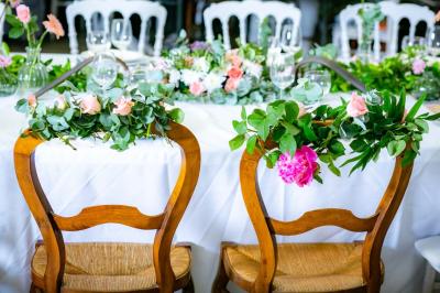 Table ronde avec verres vides, assiettes empilées, couverts, serviettes et desserts en arrière-plan.