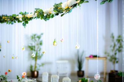 Table ronde avec verres vides, assiettes empilées, couverts, serviettes et desserts en arrière-plan.