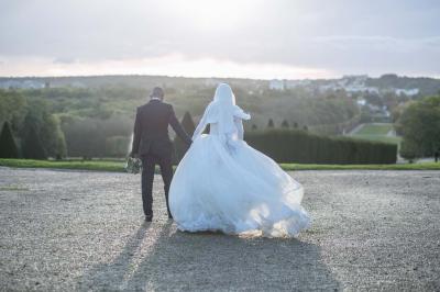 Table ronde avec verres vides, assiettes empilées, couverts, serviettes et desserts en arrière-plan.