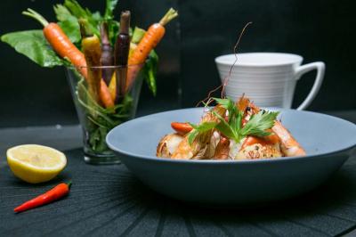 Table ronde avec verres vides, assiettes empilées, couverts, serviettes et desserts en arrière-plan.