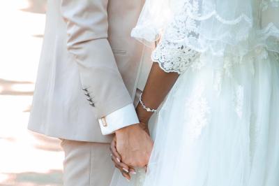 Table ronde avec verres vides, assiettes empilées, couverts, serviettes et desserts en arrière-plan.