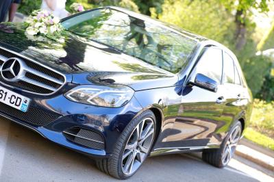 Table ronde avec verres vides, assiettes empilées, couverts, serviettes et desserts en arrière-plan.